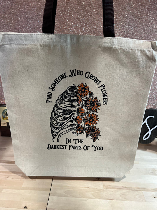FIND SOMEONE WHO GROWS FLOWERS IN THE DARKEST PARTS OF YOU TOTE